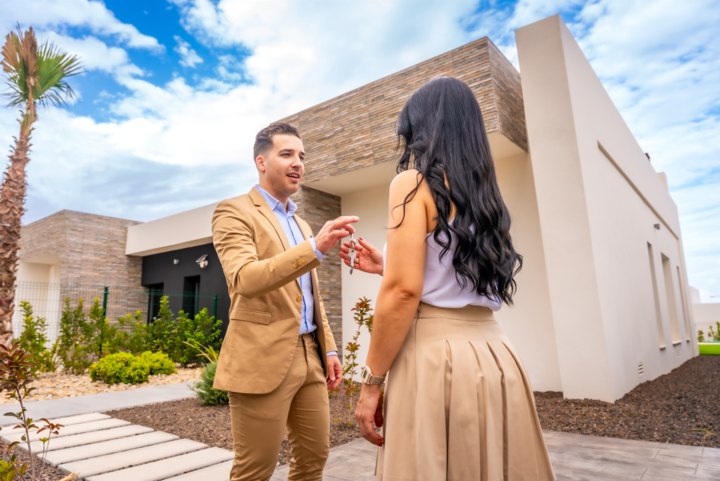 Woman receiving the keys of a new house after learning what is turnkey real estate